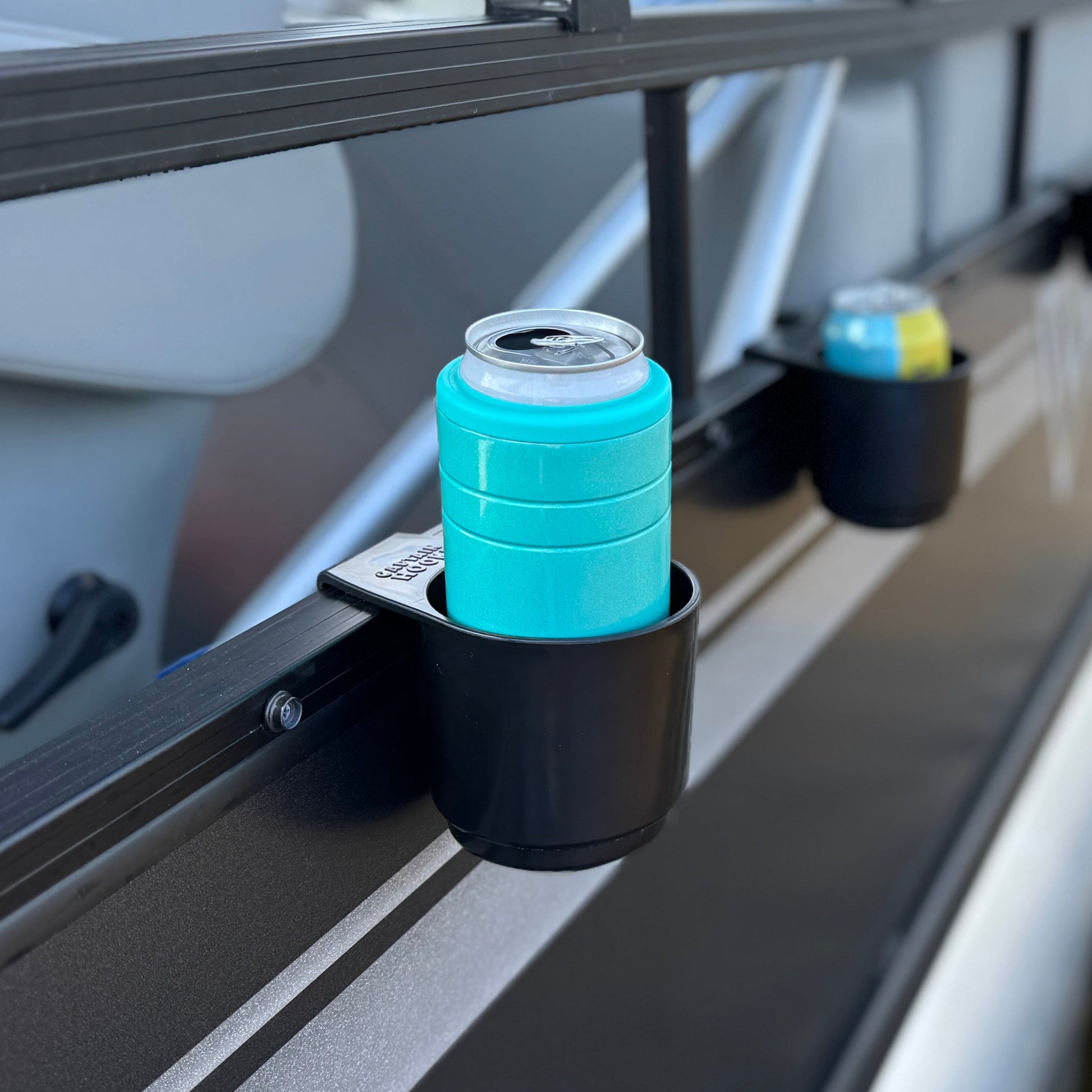 Close-up of a cup holders on the outside of a pontoon boat, water in the background